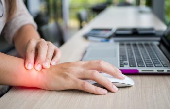 a person with wrist pain working on their laptop