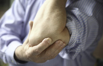 man suffering from tennis elbow pain