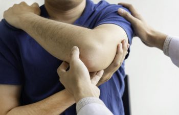 man with a shoulder injury during an appointment with a doctor