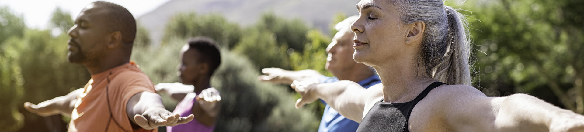 group of happy mature sporty people exercising outdoors