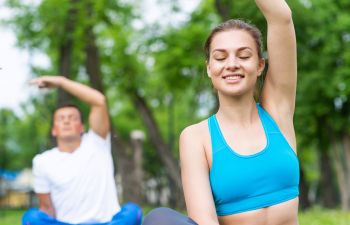 Young couple doing yoga in a park.