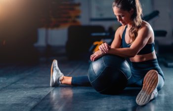 Stretching after a gym workout, a woman promotes muscle recovery and flexibility. Structured stretches reduce soreness, enhancing comfort